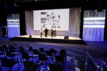 White Single Screen AV-Drop Modular Backdrop behind stage with panels accenting on sides for front projection of Atlas corporate event