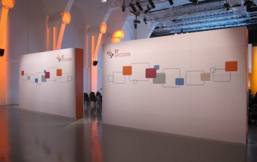 Double sided graphic print AV-Drop Modular Backdrop as divider wall for corporate meeting on one side and social event on the other